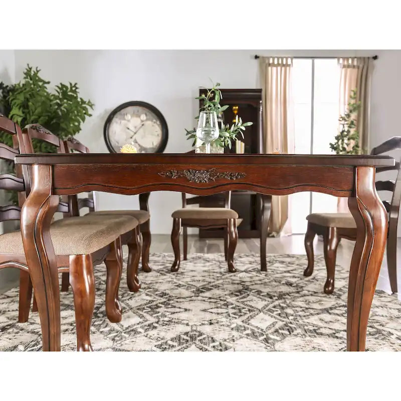 Mesa de comedor tradicional con acabado de nogal oscuro y detalles tallados