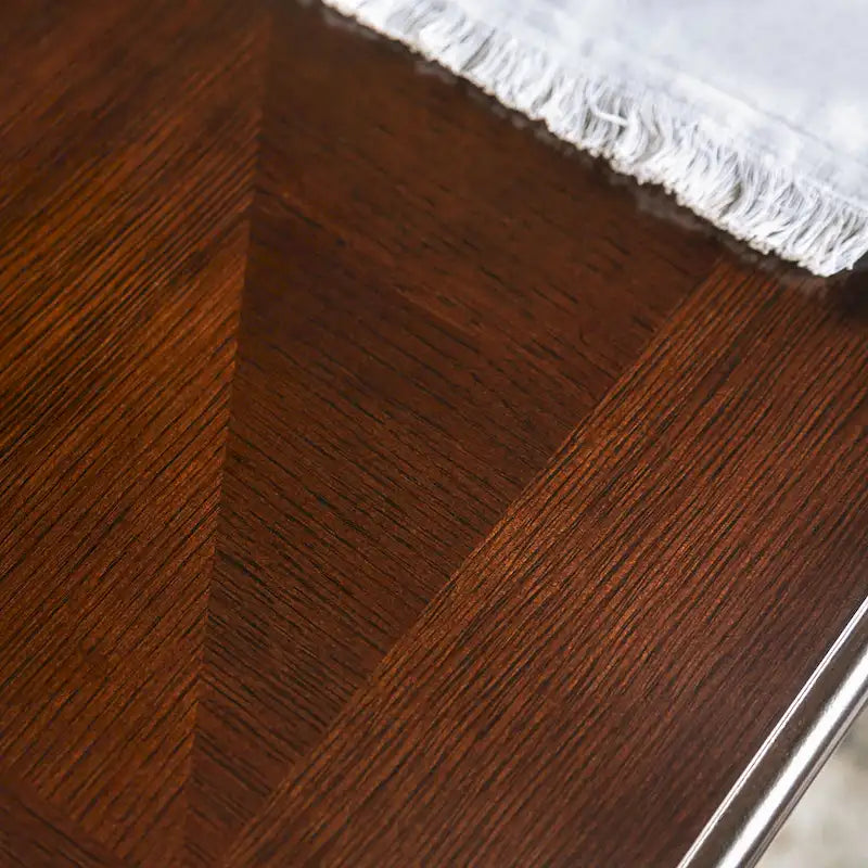Mesa de comedor tradicional con acabado de nogal oscuro y detalles tallados